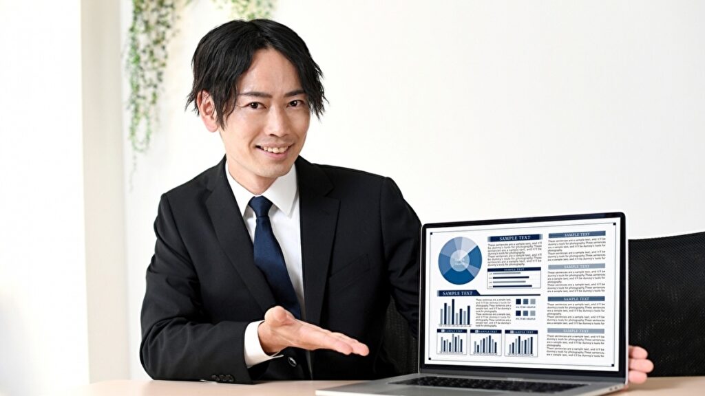 パソコンの画面で統計資料を説明する男性