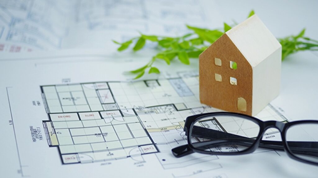 建築図面とメガネと家の模型