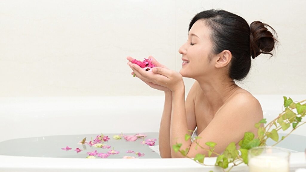 お風呂で花の香りを楽しむ女性
