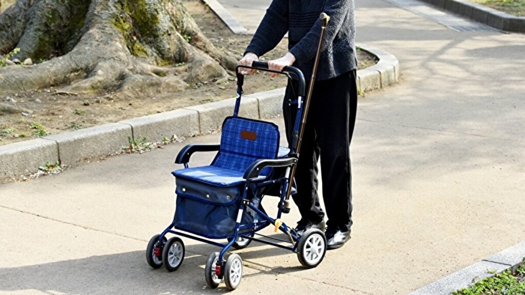 補助歩行器をおして歩く年配の女性