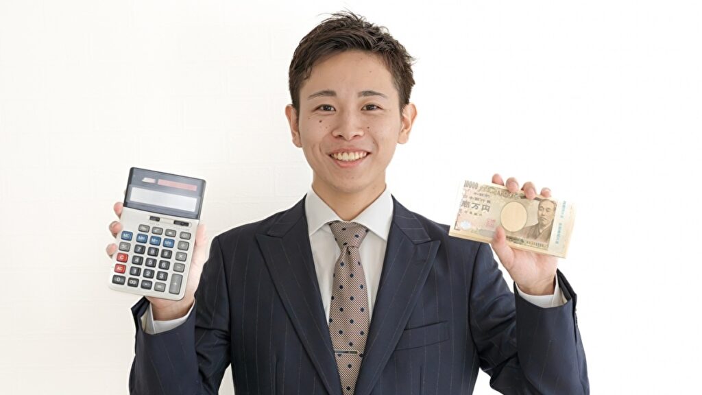 電卓と一万円札の束を持つ男性