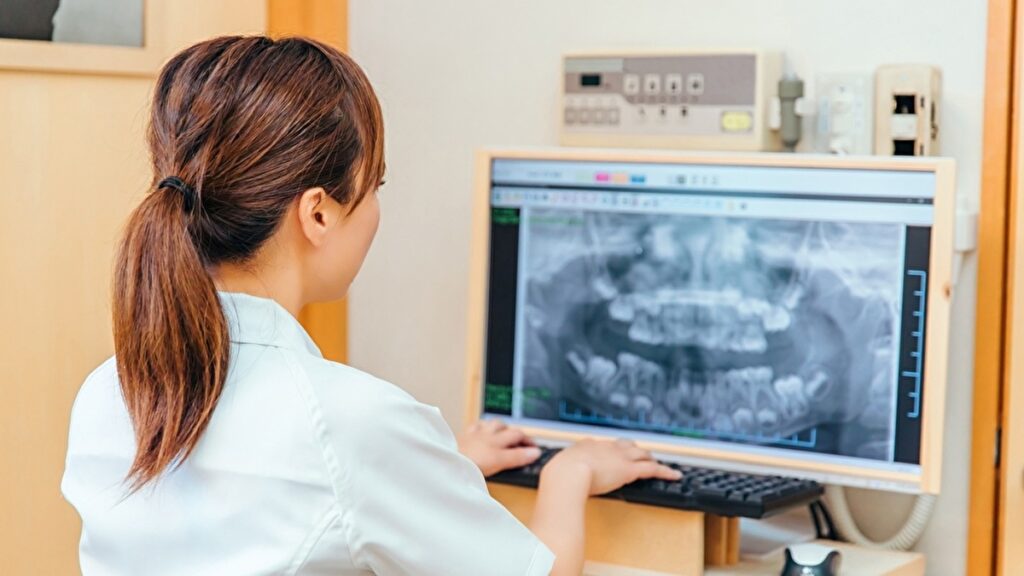 歯のレントゲン写真をパソコンで操作する女性