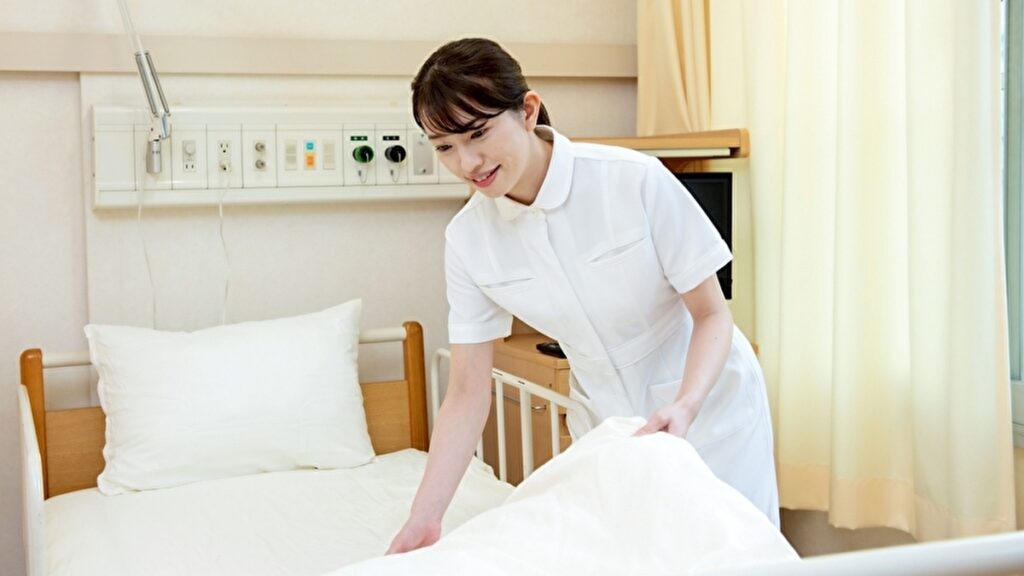 ベッドを整える若い看護師