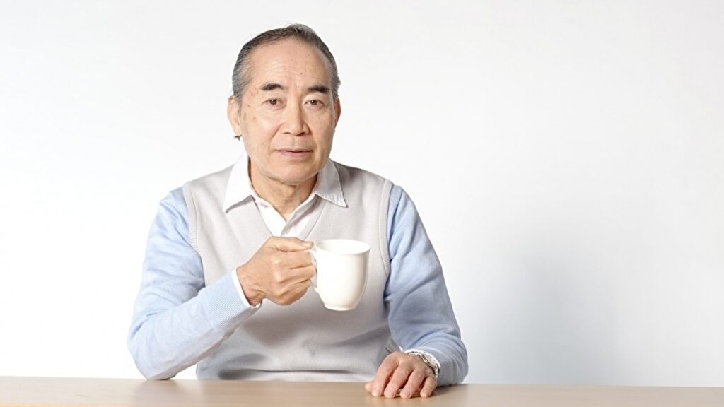 コーヒーカップを持つ年配の男性