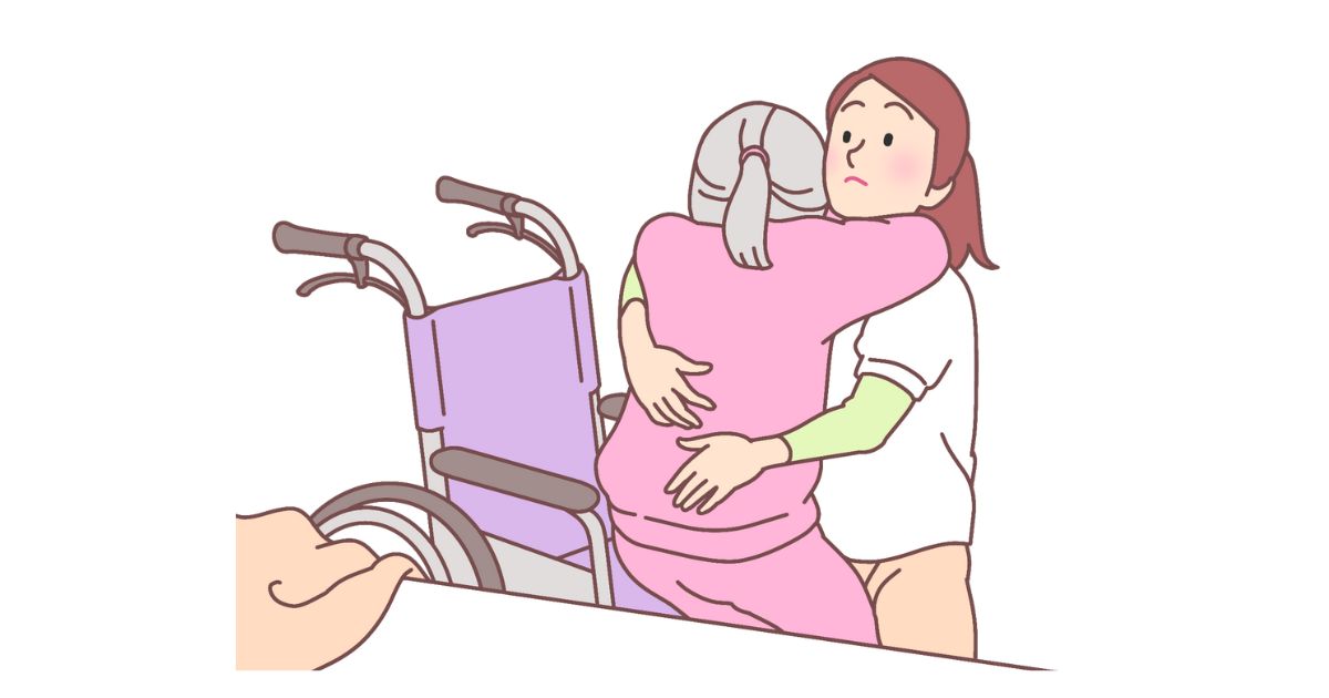 ベッドから車椅子への移動を手伝う女性介護士