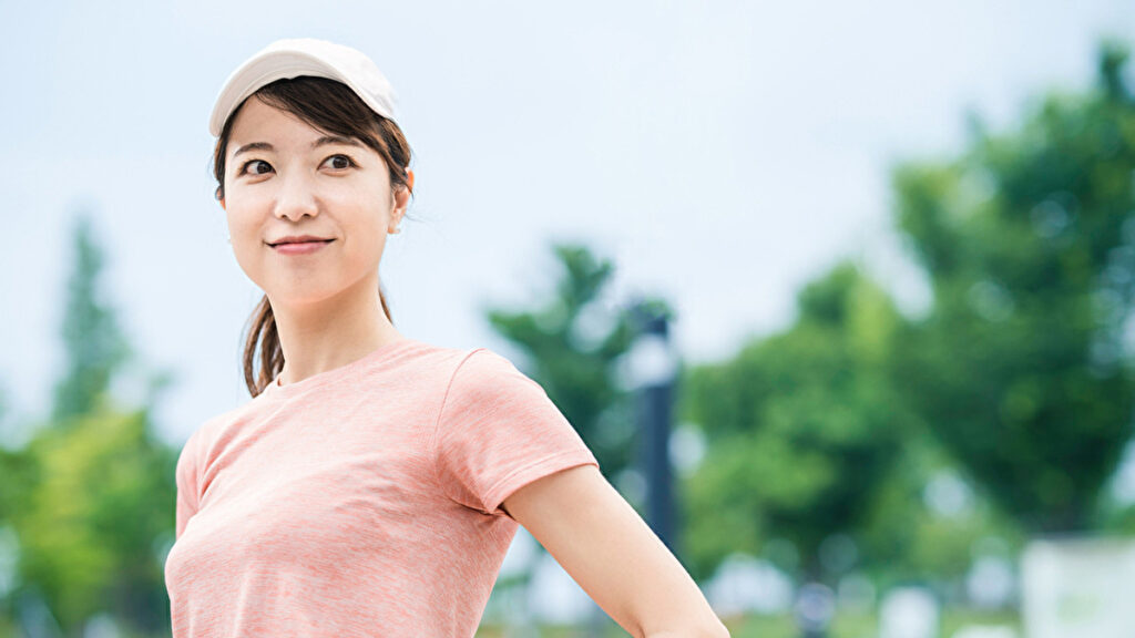 ピンク色の半袖シャツでトレーニングする女性