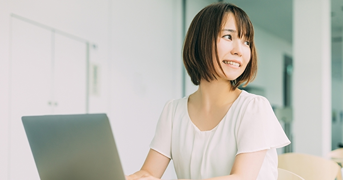 パソコンを操作しながら振り返る女性