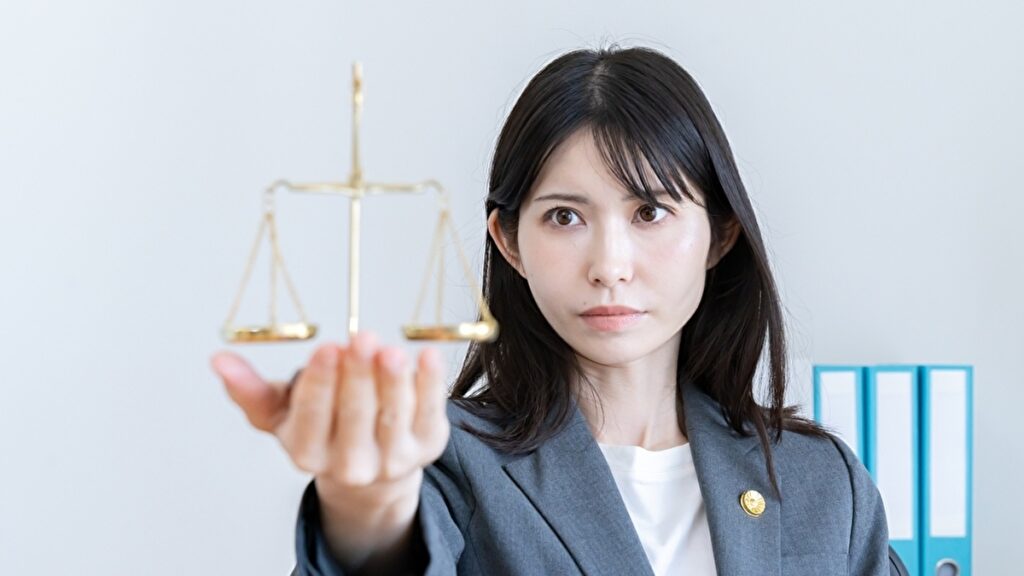 弁護士のシンボルとなる天秤を持つ女性